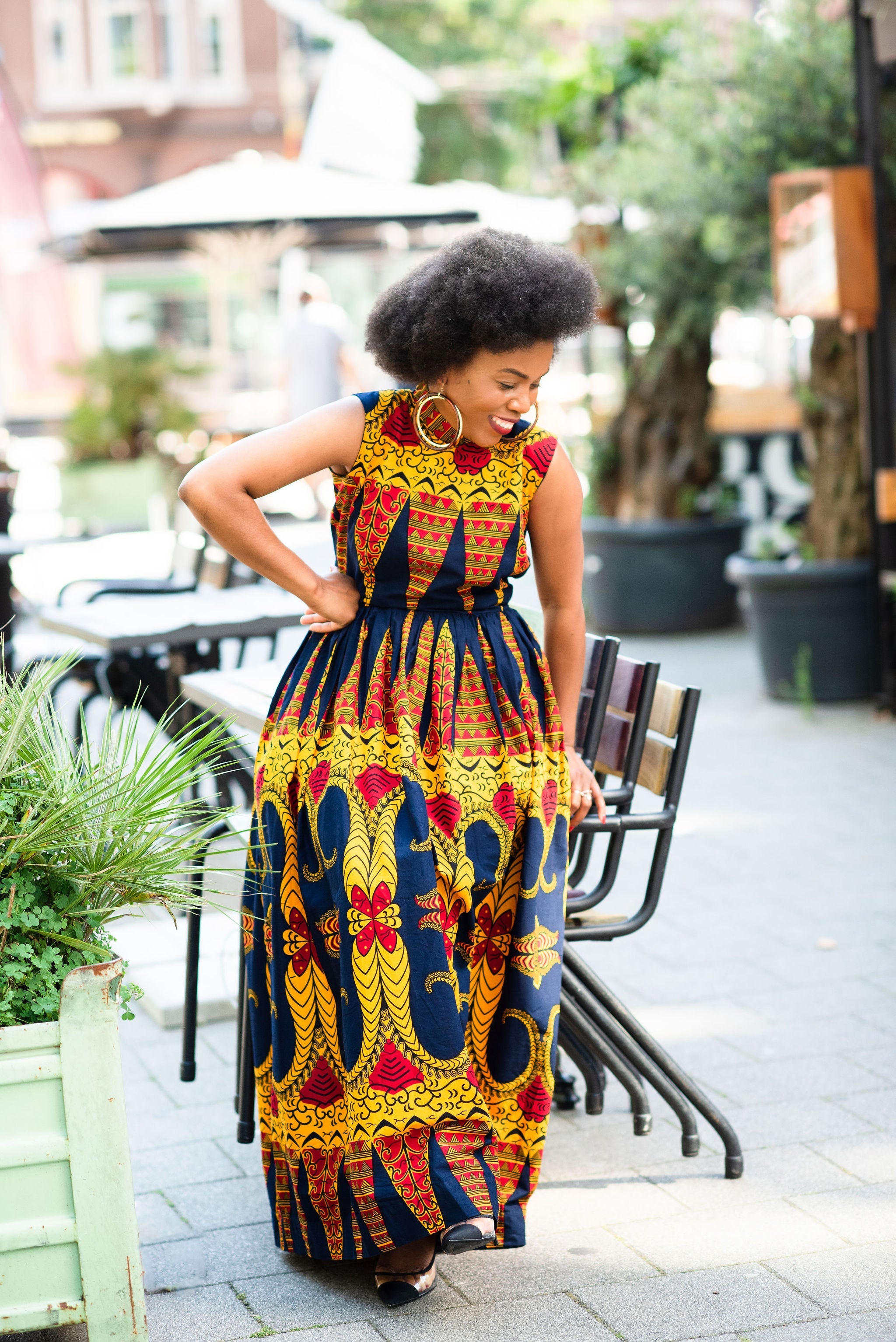 Model wearing an African print sleeveless Ankara Maxi dress in Navy blue & Orange