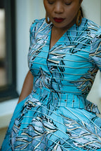 Close up detail of Aqua and Ivory Gold African print Midi Dress with V neckline & matching Belt.