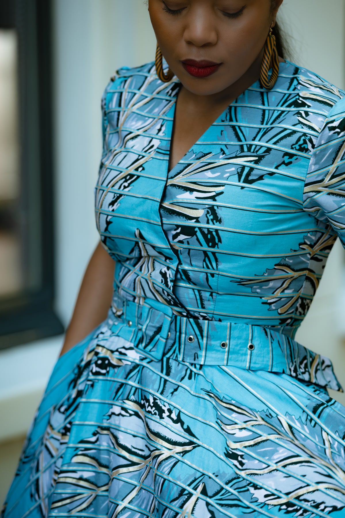 Close up detail of Aqua and Ivory Gold African print Midi Dress with V neckline & matching Belt.