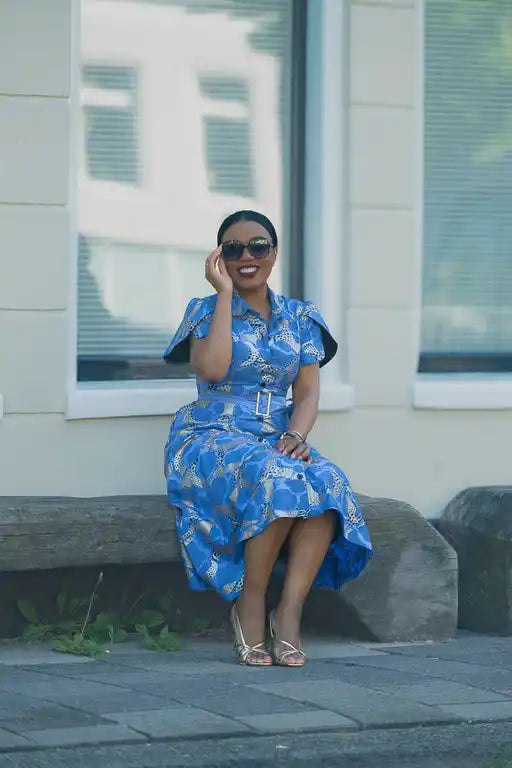 Model Sitting in a Blue African Colorful print Ankara Midi Dress