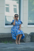 Model Sitting in a Blue African Colorful print Ankara Midi Dress