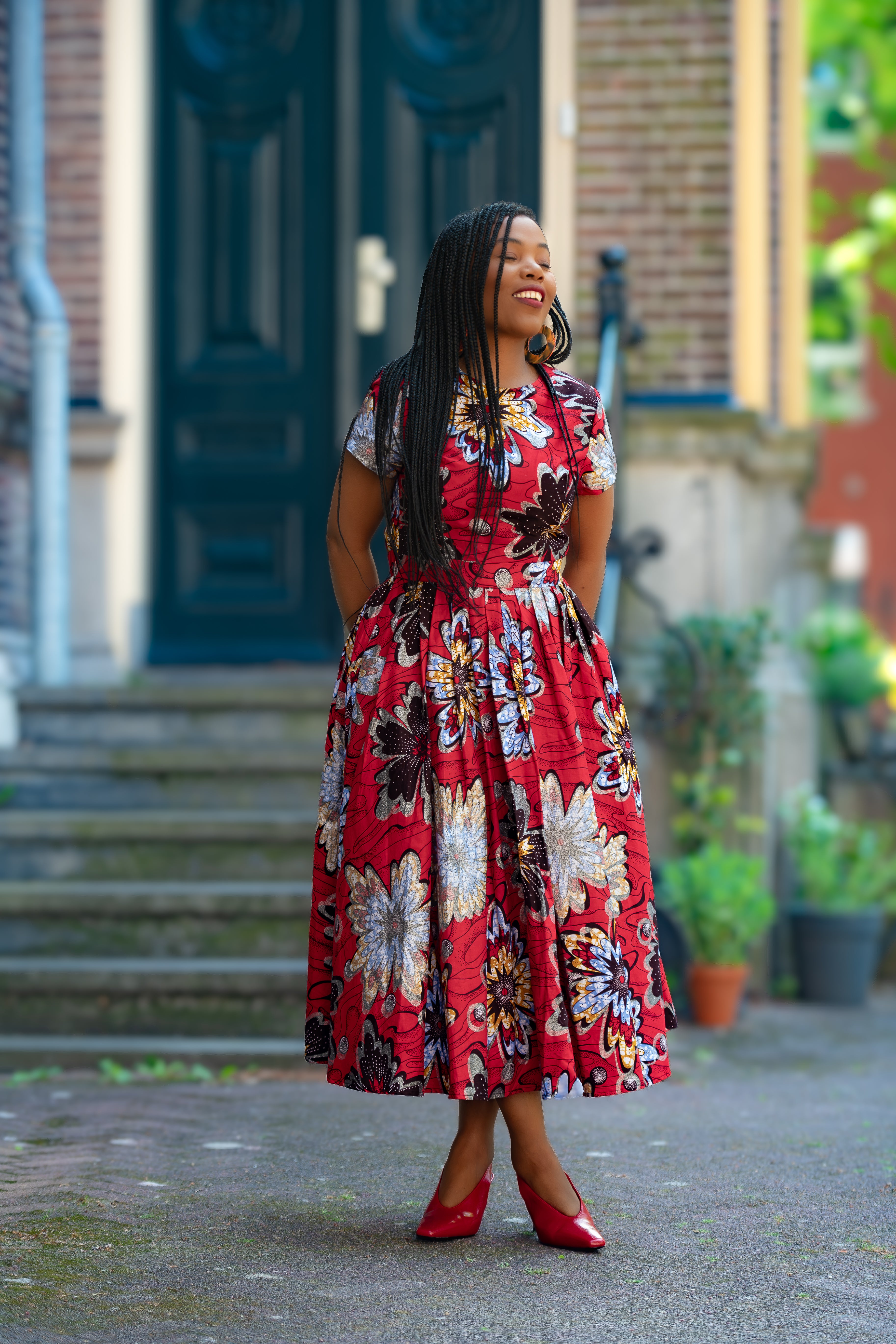 A model wearing a 100% Cotton African floral print Women's fashion outfit in Red & Silver by Heritage Clothings