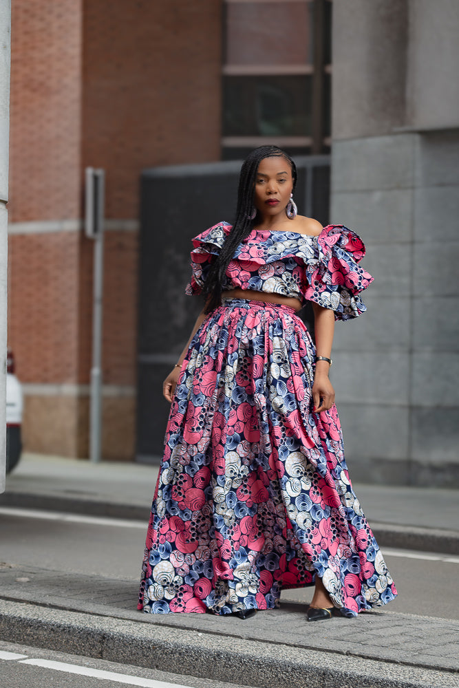 Model wearing a floral outfit on a city street.