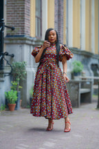Model wearing a woven African print Ankara dress with puff sleeves by Heritage Clothings