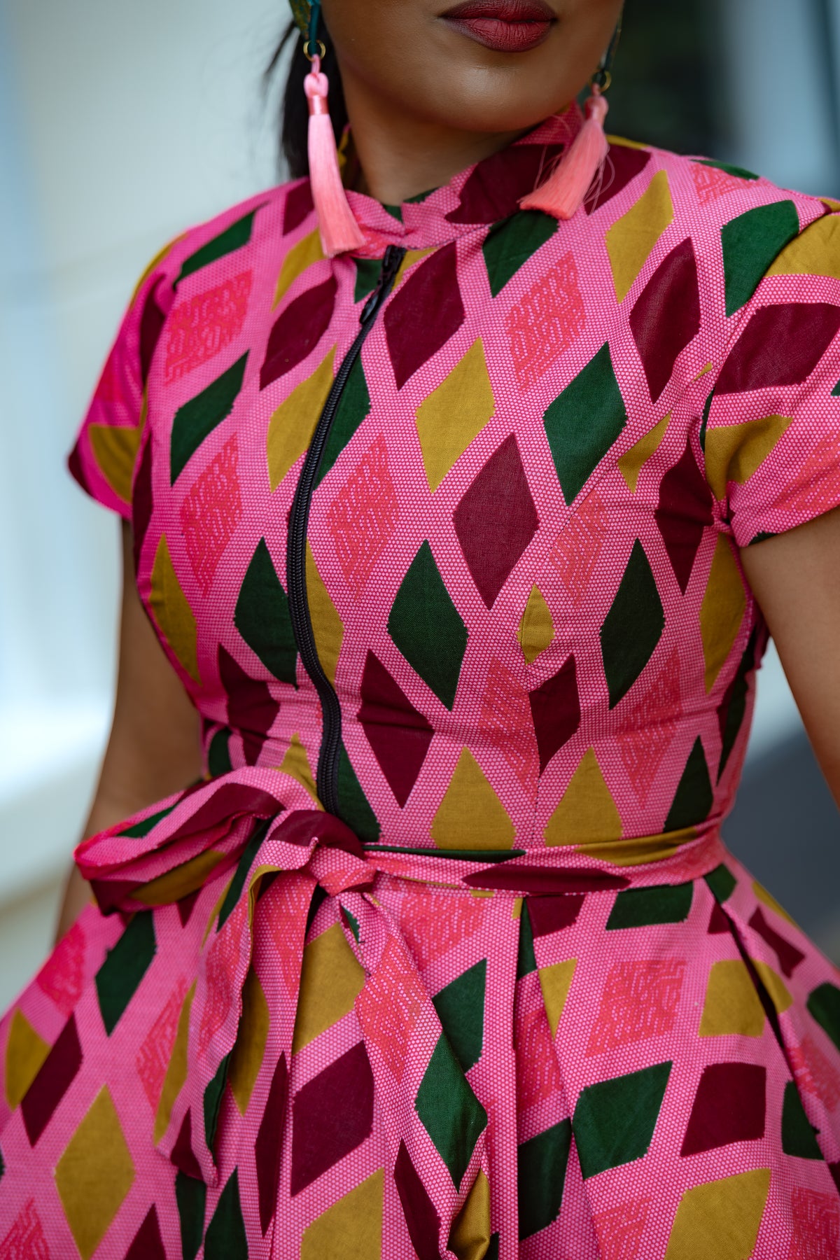Close up detail of Pink African print Cotton Peplum Top with Front Zipper, waist Tie and matching Skirt.