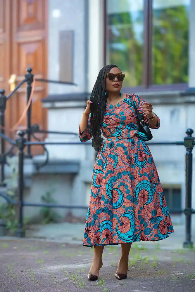 Floral African print Ankara maxi dress styled with a black bag 