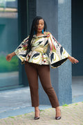 Model wearing small on the Zinitha floral top and brown pants standing outdoors.